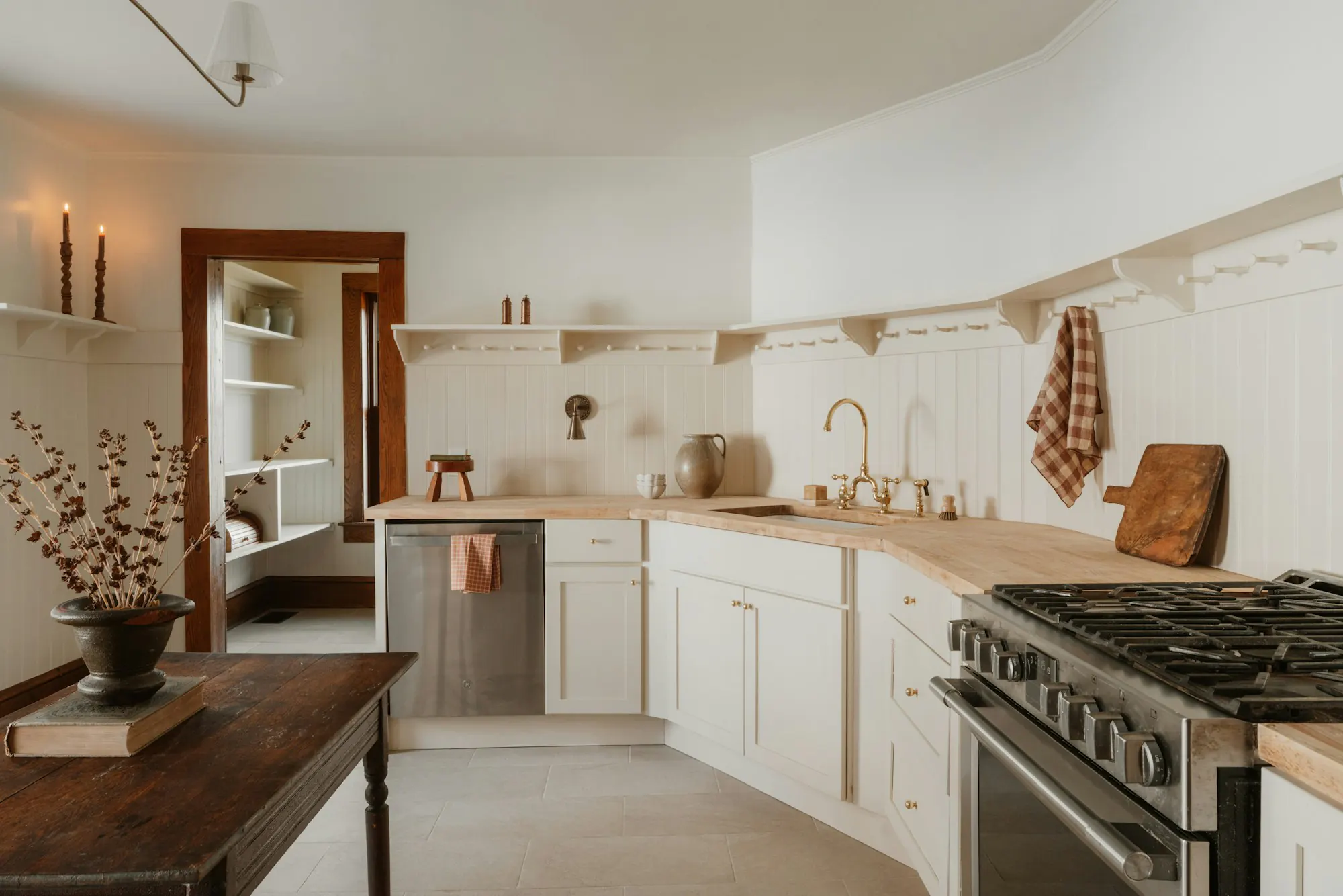 Bright farmhouse kitchen with white cabinets and wooden counters