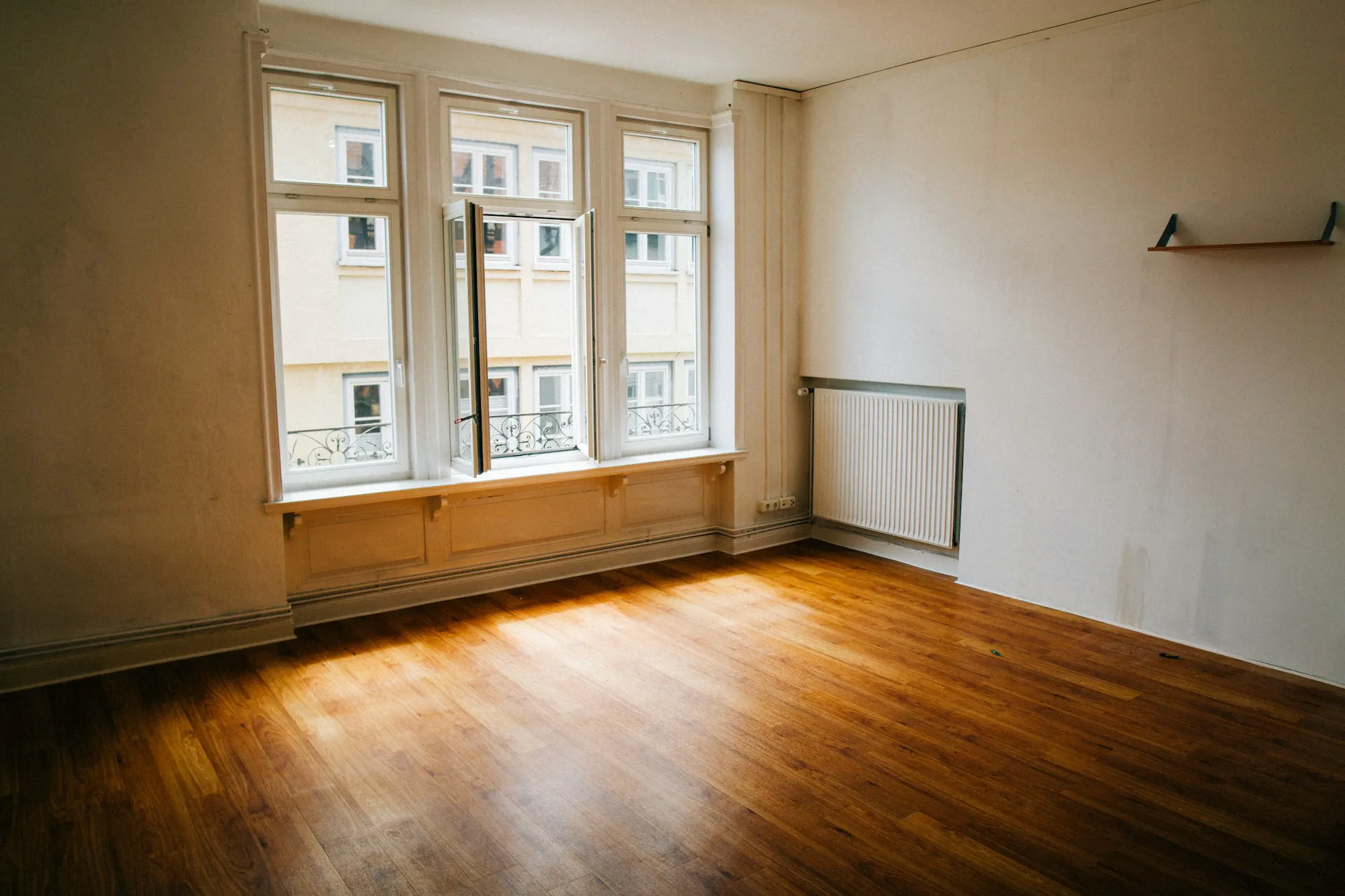 Empty room with sunlit hardwood floors