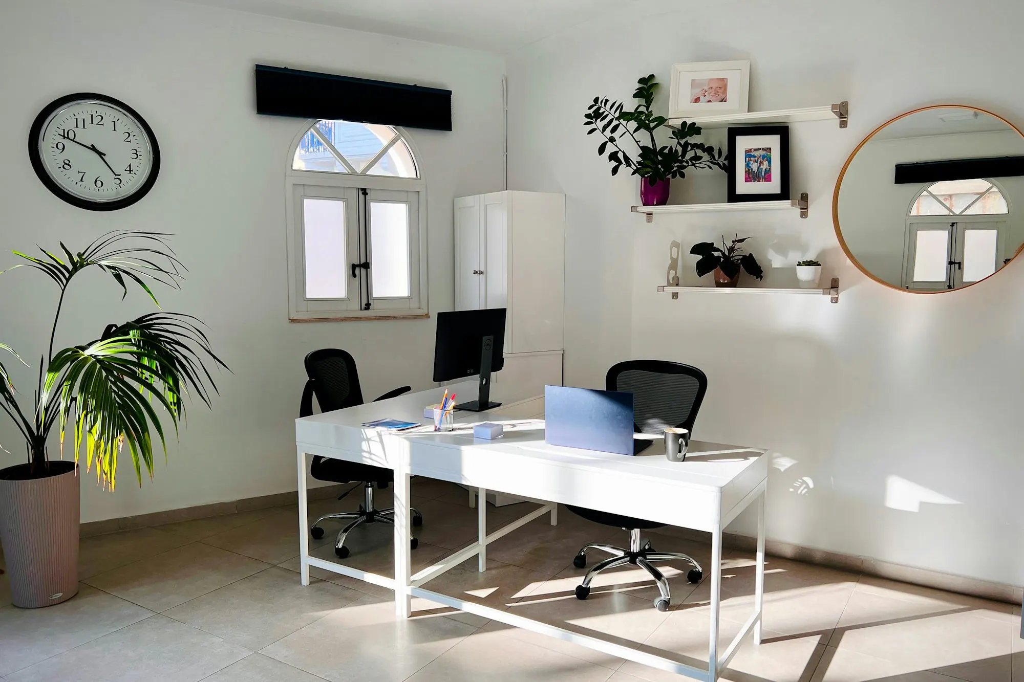 Bright, tidy office with a white desk and plants