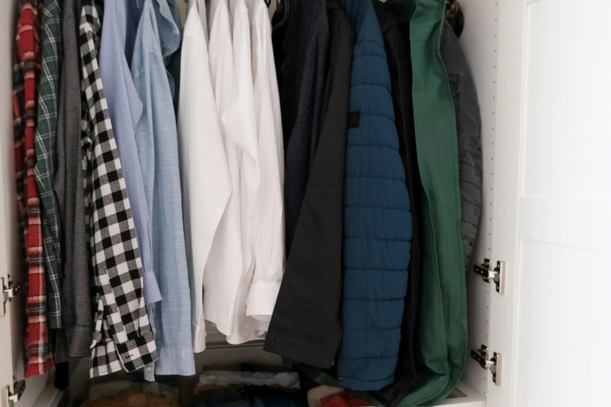 Neatly hung shirts and jackets in a closet