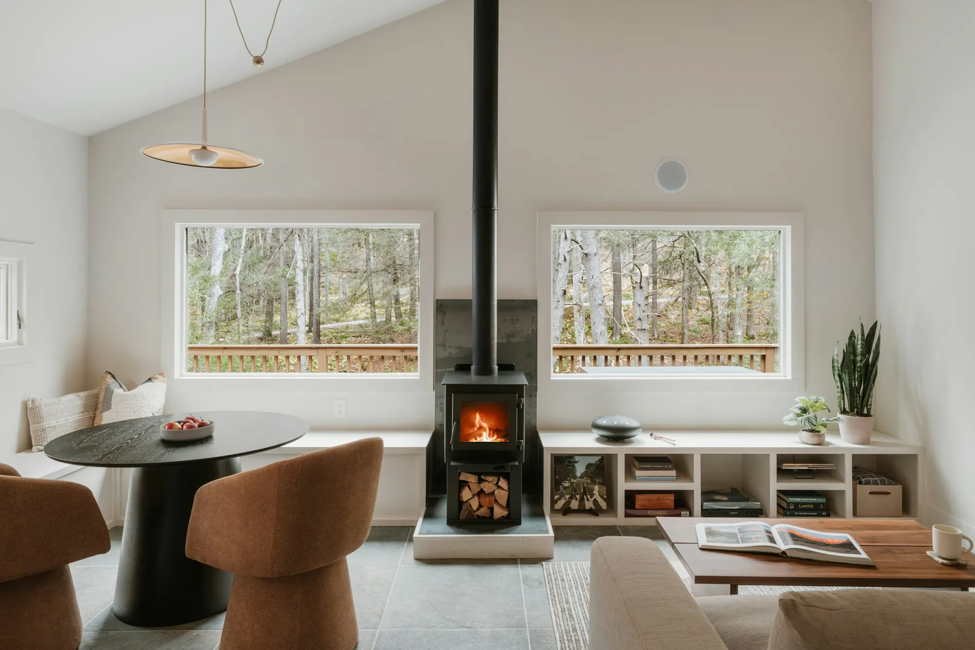 Living room with a wood stove and large windows