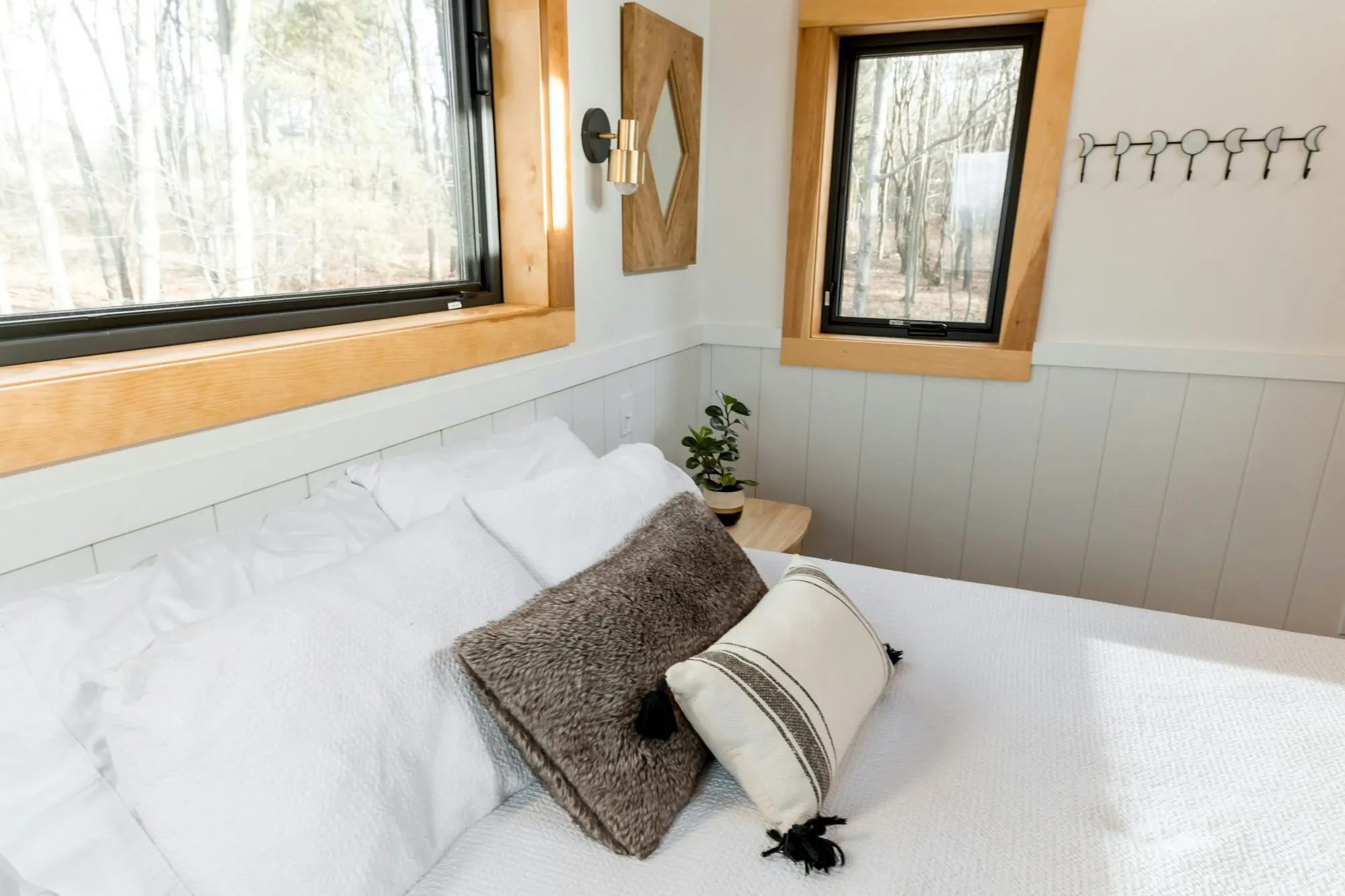 Bedroom with a white bed under a wooden ceiling