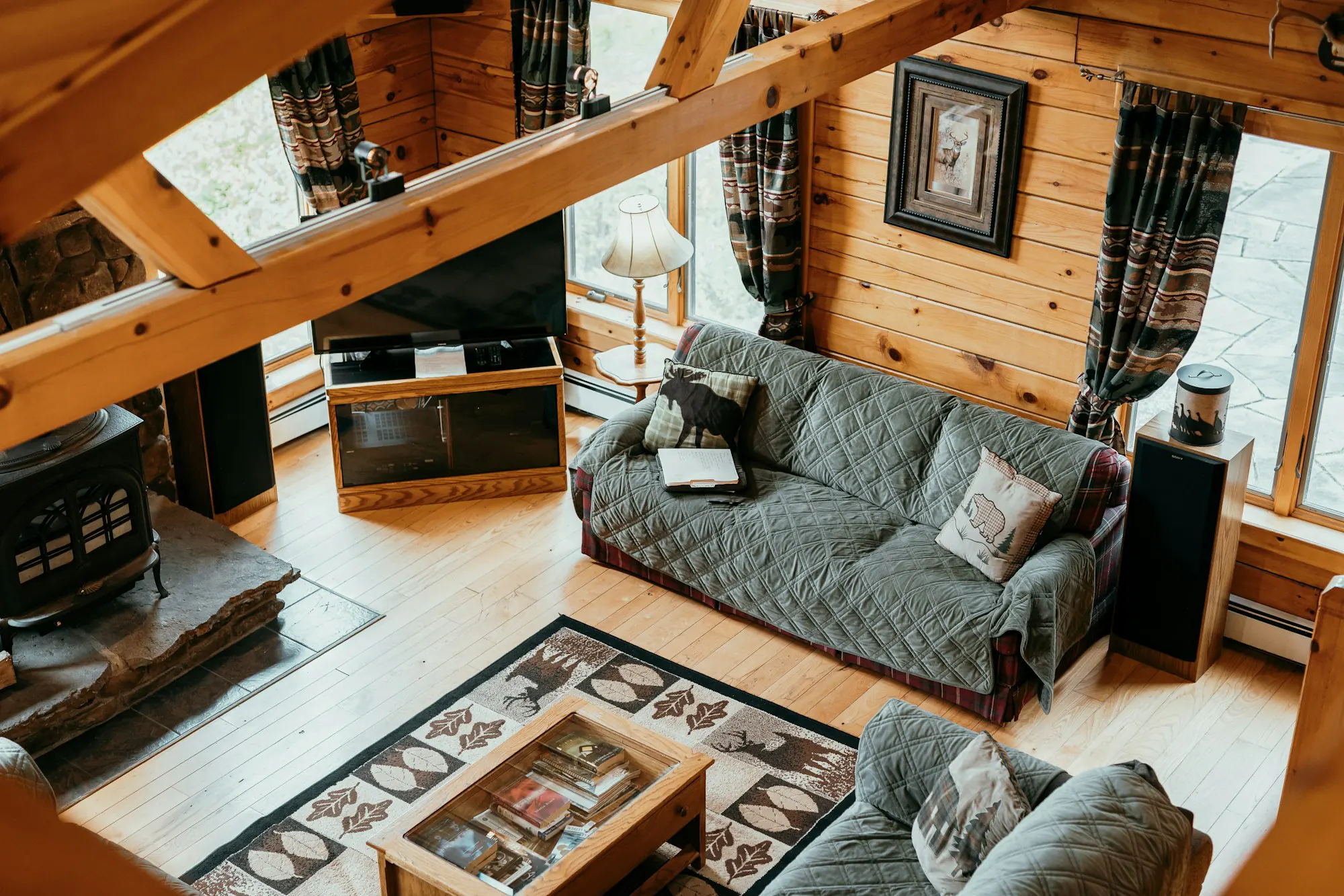 Bright cabin living room with a wood stove and wooden floors